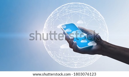 Cloud Computing. Hand holding smartphone with flying data storage cloud icons over world globe with polygonal dots wireframe, creative background