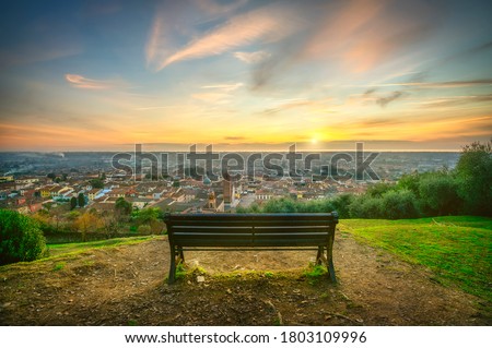 Park bench and Pietrasanta aerial view from Rocca di Sala fortress at sunset. Versilia Lucca Tuscany Italy Europe Royalty-Free Stock Photo #1803109996