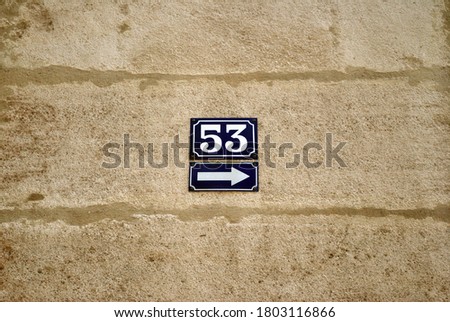 Close Up of Blue Ceramic Plaques on Stone Wall with Arrow & Number 53