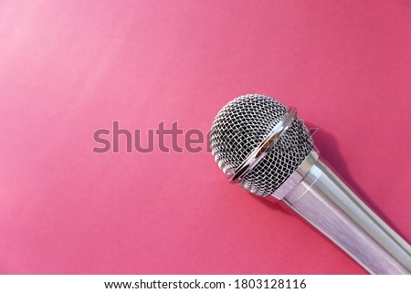 The microphone is on a bright pink background. The view from the top.