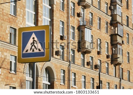 Pedestrian crossing signboard on building background.