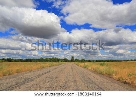 landscape with old countryside road under nice clouds in sky