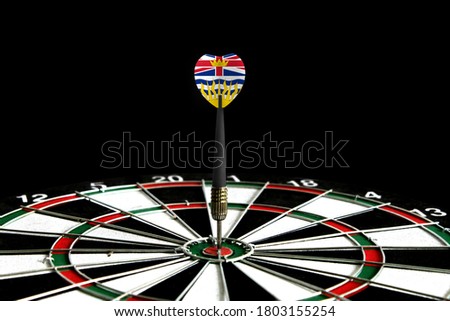 The flag of British Columbia is featured on the dart board game, the concept of achieving goals.