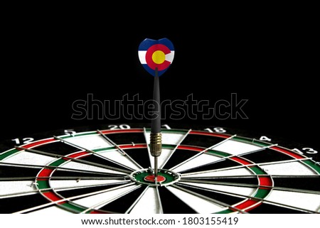 The flag of State of Colorado is featured on the dart board game, the concept of achieving goals.