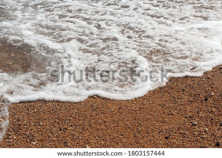 gentle sea surf runs on the sandy beach. Beach background photo.