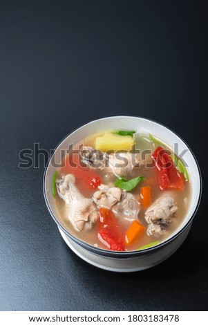 Clear chicken soup in a white bowl