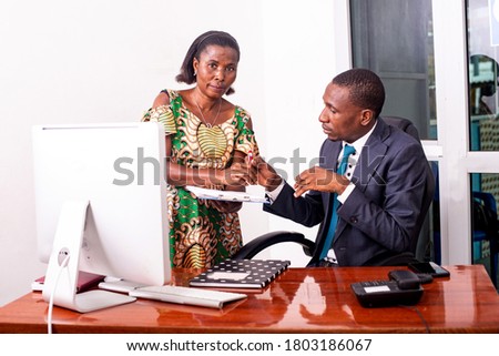 portrait of serious businessman and his secretary working together in the office.