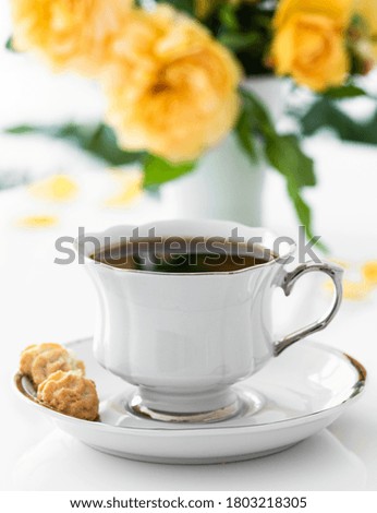 cup of coffee. Good morning. Yellow flowers on white table