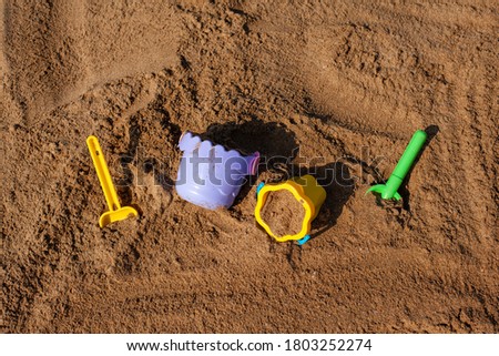 Children's games on the sea on the sandy beach. Children's buckets and shovels.