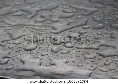 A steel made surface and collective rain drops in different shape all over it.