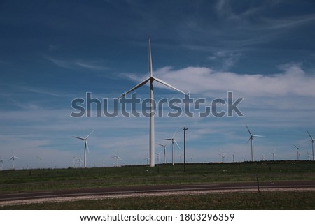 Windmills along side road on a sunny day. pic from car window while driving