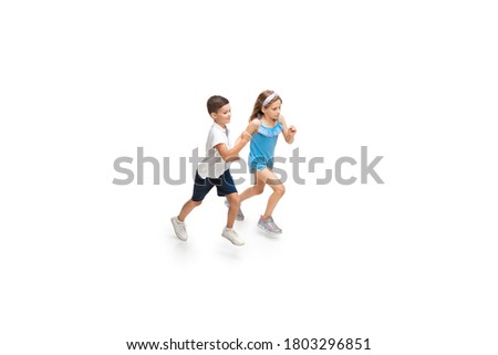 Happy little girl and boy running on white background, happiness