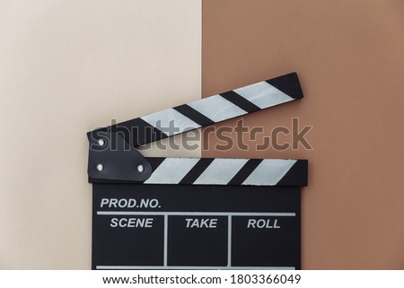 Movie clapper board on beige brown background. Filmmaking, Movie production, Entertainment industry. Top view