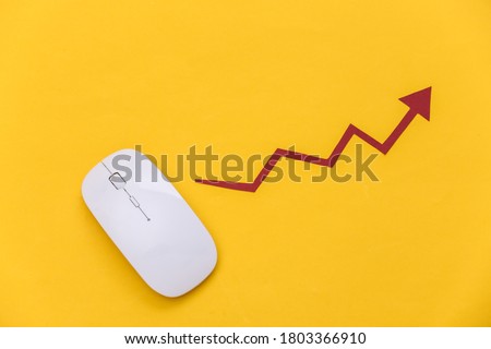 White mouse with a rising arrow on a yellow background. Online business, trading. Top view. Flat lay