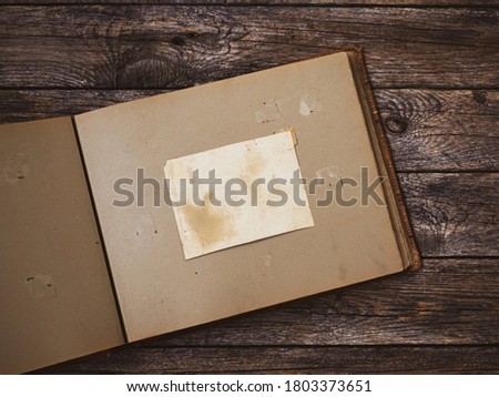 Clear blank photo frames to placed your pictures or text on old family album on wooden board background in retro style. Family traditions, memore and nostalgia concept Royalty-Free Stock Photo #1803373651