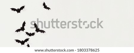 Halloween and decoration concept - black paper bats flying over white background
