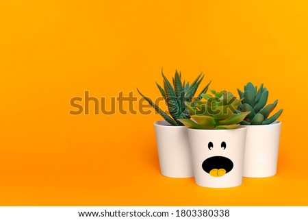 White plant pots with funny monster faces on orange background. Space for text. Halloween festival background concept. 31 october