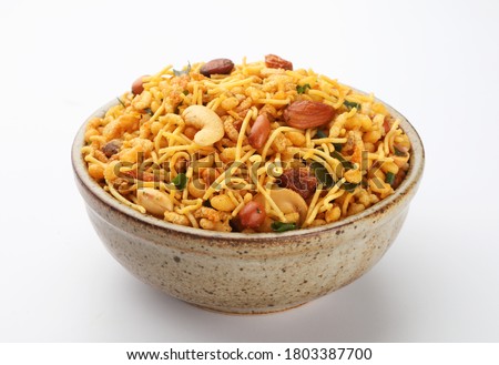 Indian Namkeen Snacks served in ceramic bowl & plate or Indian traditional Namkeen Food Mixture or Navratna Mix Namkeen Also Know as Nimco, Namkin, Mixture ,chiwda or Nimko

 Royalty-Free Stock Photo #1803387700