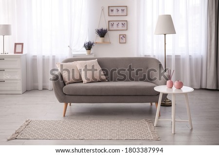 Stylish sofa in beautiful living room interior