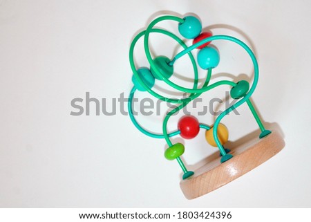 multicolored children's toy isolated on white background. Developing logistic toy Labyrinth with beads.