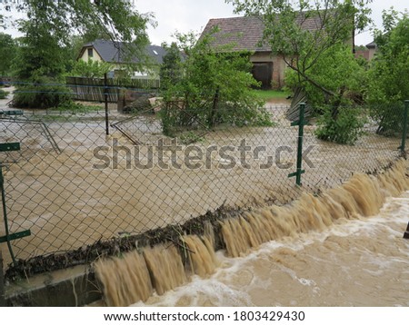 
flowing water in the garden through the fence during floods