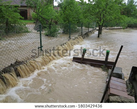 
flowing water in the garden through the fence during floods