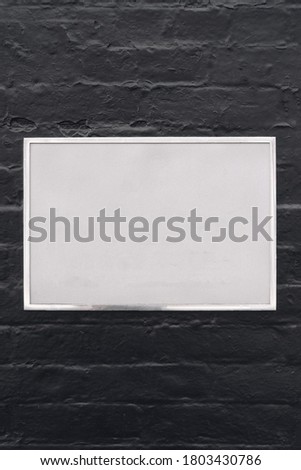 Silver metal stainless steel plate sign on black brick wall texture background, nameplate, company name logo template, mockup. Copy space for text