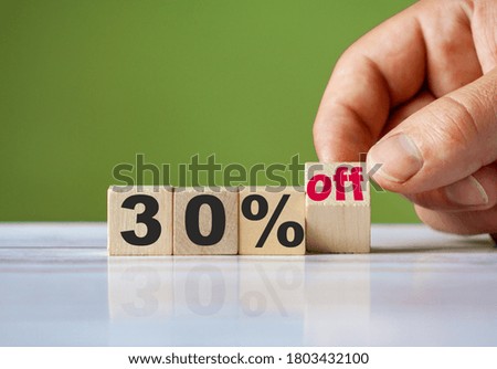The hand turn wooden block and change word to 30% off. Sale background concept.