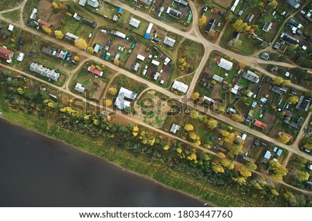 Top view of the grid of streets and roads in the village with houses and river. Map of the area, photograph from the drone.