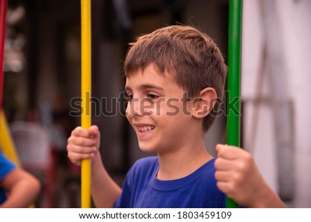 A smiling boy is swinging on a swing
