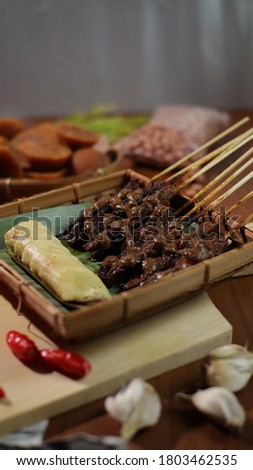 Chicken satay, a food that many Madurese sell with lontong and peanut sauce as a complement to the dish.  this picture perfect for your commercial purposes
