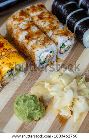Set of traditional Japanese dishes. Sushi rolls, nigiri, raw salmon, rice, cream cheese, avocado, pickled ginger.