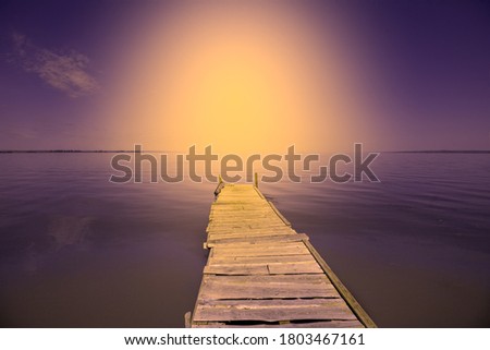 Travel and vacation concept. Wooden pier in the sea during sunset. Seascape in the evening. Wooden pier in the lake