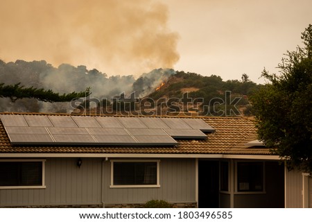 The California "River Fire" of Salinas,  in Monterey County, was ignited by dry lightning on August 16, 2020, fills the sky with dark smoke and flames as it burns close to a house. Royalty-Free Stock Photo #1803496585