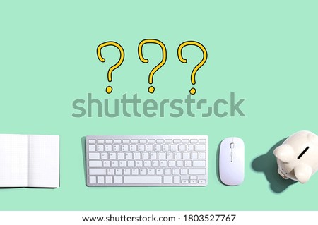 Question marks with a computer keyboard and a piggy bank
