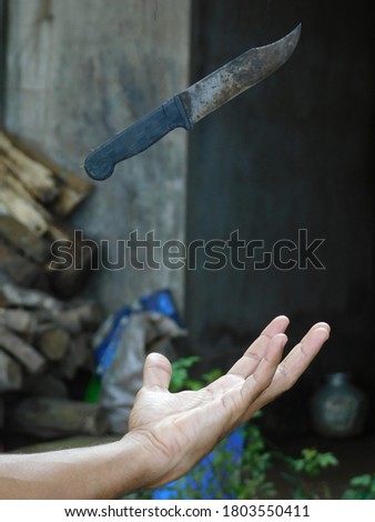Creative photography concept. View of man's palm under the knife blur background 