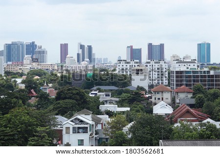 Beautiful clear blue sky,Modern building background in Bangkok,There are trees and houses in front of the view.