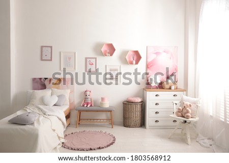 Modern teenager's room interior with comfortable bed and beautiful pictures