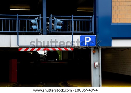 Entrance of a car parking garage with signal lights and a blank sign