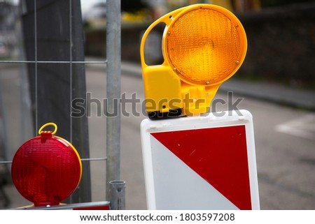 Close-up of red warning lights with street barriers at a construction site