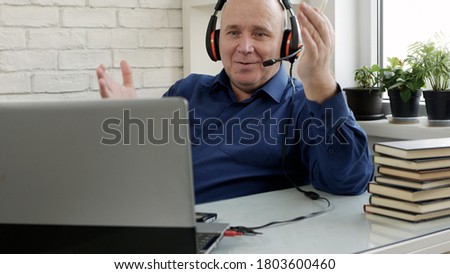 Image with a Person Using a Laptop and Headphones for an Online Video Conference