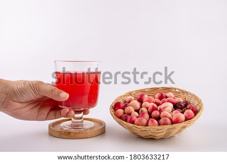 Carandas-plum juice in glass on white background.