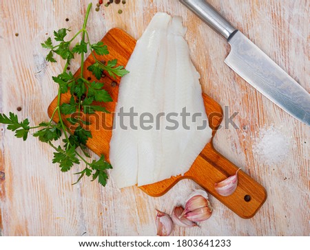 Raw seafood, fresh fillet halibut fish on wooden board