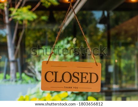Closed Sign Hanging on Glass Door: Temporary Closure of Business
