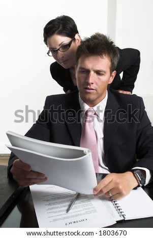 Young businessman and his assistant are looking-over business documents.