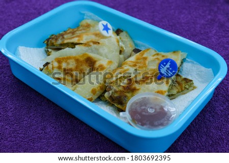 Selective focus picture of "murtabak" in breakfast pack by a wife for her husband. Murtabak is a stuffed pancake or pan-fried bread which is commonly found in the Arabian Peninsula and Southeast Asia.