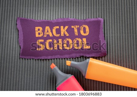 BACK TO SCHOOL. Text on torn, colored paper on corrugated background