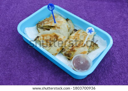 Selective focus picture of "murtabak" in breakfast pack by a wife for her husband. Murtabak is a stuffed pancake or pan-fried bread which is commonly found in the Arabian Peninsula and Southeast Asia