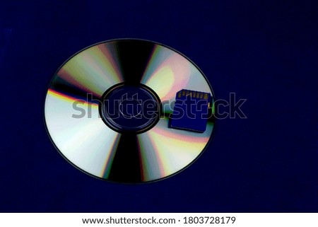 Compact disc and memory card isolated on a blue background