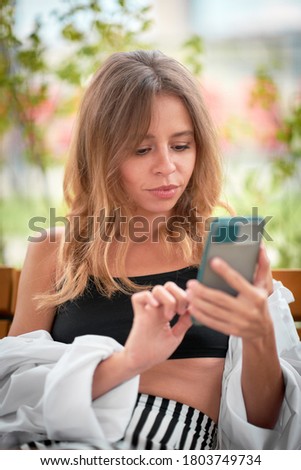 Woman looks at smartphone screen